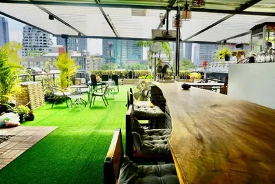 a bar in a building with a green floor at Hash Apartment Silom Soi 3 triple room in Bang Rak