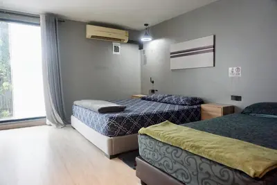 a hotel room with two beds and a window at Hash Apartment Silom Soi 3 triple room in Bang Rak