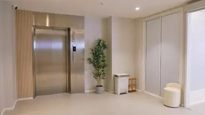 a hallway with a metal door and a potted plant at The Staytion Hotel at Sukhumvit in Amphoe Phra Khanong