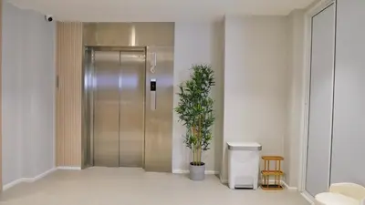 a hallway with a metal elevator with a potted plant at The Staytion Hotel at Sukhumvit in Amphoe Phra Khanong