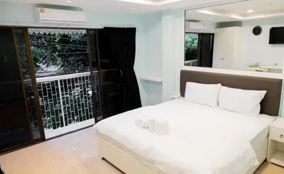 a bedroom with a white bed and a balcony at Cozy Stay Inn in Bang Kapi