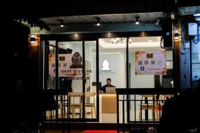 a man sitting at a table in a restaurant at Cozy Stay Inn in Bang Kapi