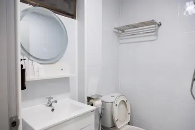 a white bathroom with a sink and a mirror at Cozy Stay Inn in Bang Kapi