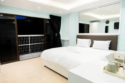 a bedroom with two beds and a large window at Cozy Stay Inn in Bang Kapi