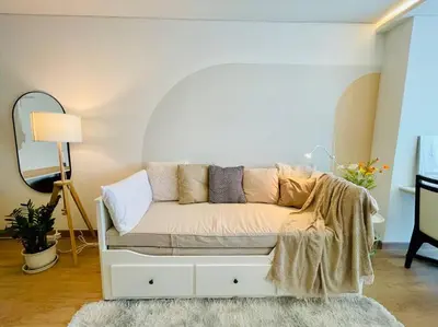 a white couch in a room with a mirror at Cozy Spacious 55sqm 1BR 200m BTS PhraKhanong, 10min Thonglo in Bangkok