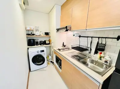 a small kitchen with a sink and a washing machine at Cozy Spacious 55sqm 1BR 200m BTS PhraKhanong, 10min Thonglo in Bangkok