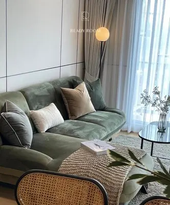 a living room with a green couch and a table at Luxury room in Ban Khlong Bang Chak