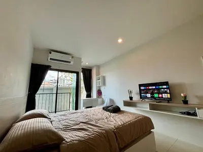 a bedroom with a bed and a flat screen tv at 5 mins to Ari - Sutthisan in Bang Su