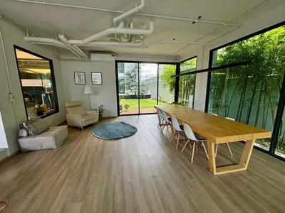 a living room with a wooden table and chairs at 5 mins to Ari - Sutthisan in Bang Su