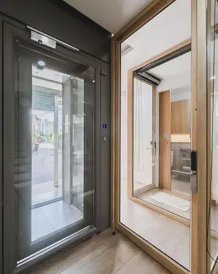 two glass doors in a room with a hallway at Sweet stay in Bangkok