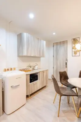 a kitchen with a refrigerator and a table and chairs at Sweet stay in Bangkok