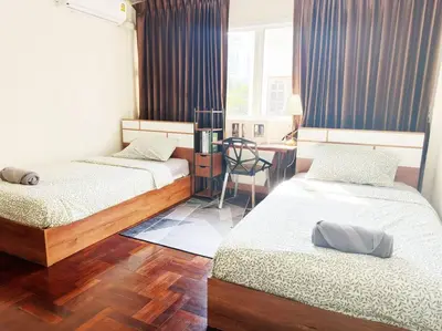 a bedroom with two beds and a desk with a chair at 5BR House 8Beds, Ekkamai BTS 12mins walk, 711, shopping mall in Bangkok