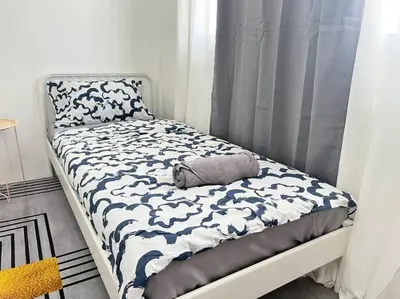 a bed with a blue and white comforter on it at 5BR House 8Beds, Ekkamai BTS 12mins walk, 711, shopping mall in Bangkok