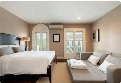 a bedroom with a large bed and a couch at Sukhumvit 16 Townhouses, InHome Luxury Residences in Bangkok