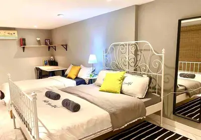 a bedroom with two beds with yellow pillows at 5BRHouse City centre Silom 3min to BTS Saint Louis in Bangkok