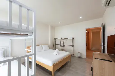 a bedroom with a bed and two bunk beds at Forfam at Ekkamai in Khlong Toei