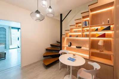 a room with a table and chairs and a staircase at Forfam at Ekkamai in Khlong Toei