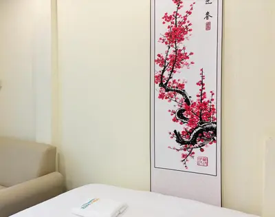 a painting of a tree with red flowers on a wall at Apamet Hotel Sukhumvit 55 in Khlong Toei