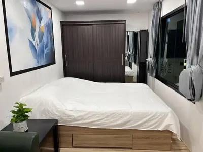 a bedroom with a white bed and a wooden cabinet at \u72ec\u7acb\u5ead\u9662 \u82b1\u56ed\u5f0f\u7684\u4e24\u5367\u4e24\u536b\u6c11\u5bbf \u8fd1mrt 2 in Bang O