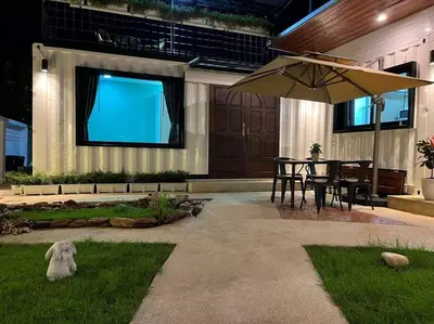 a patio with a table and an umbrella in front of a screen at \u6d6a\u6f2b\u82b1\u56ed\u7684\u4e24\u5367\u6c11\u5bbf \u72ec\u7acb\u5ead\u9662 \u8fd1mrt 3 in Bang O