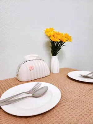 a table with two white plates and a vase of flowers at 807-STP Homely room Free Wi-Fi and Near BTS line in Ban Yang