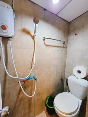 a bathroom with a toilet with a hose attached to the wall at 807-STP Homely room Free Wi-Fi and Near BTS line in Ban Yang