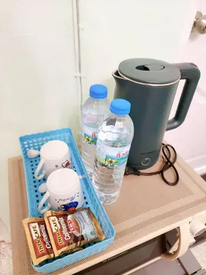 a table with a coffee pot and water bottles at 807-STP Homely room Free Wi-Fi and Near BTS line in Ban Yang