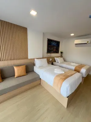 a room with two beds and a couch in it at V32 Hotel in Ban Zong Katiam