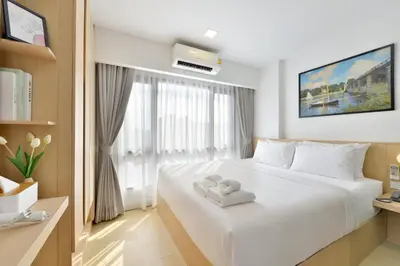 a bedroom with a white bed and a window at V32 Hotel in Ban Zong Katiam