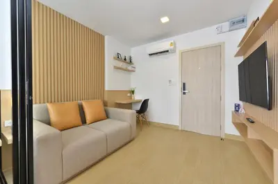 a living room with a couch and a flat screen tv at V32 Hotel in Ban Zong Katiam