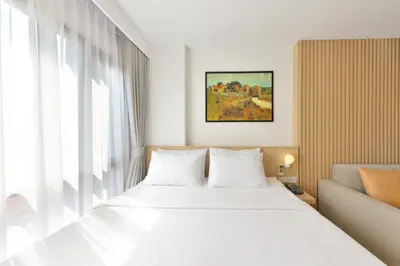 a bedroom with a white bed and a window at V32 Hotel in Ban Zong Katiam