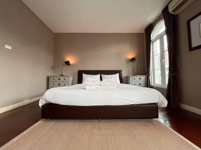 a bedroom with a large bed with white sheets and pillows at 3BR Sukhumvit Townhouse, close to Emsphere and BTS MRT in Bangkok