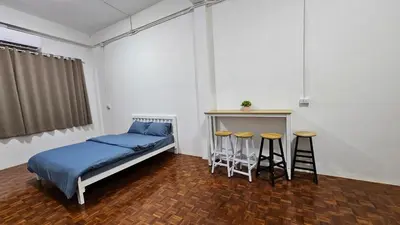 a bedroom with a bed and two stools in it at NAN Square in Pratunam