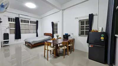 a room with a table and a bedroom with a bed at NAN Square in Pratunam