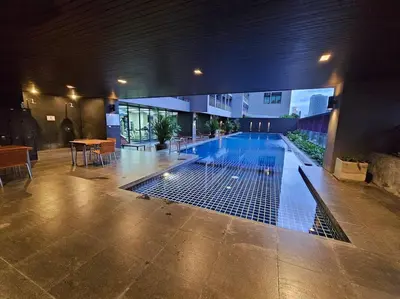 a swimming pool in the middle of a building at 1BR at ThongLor BTS overlooking city with Workspace in Bangkok