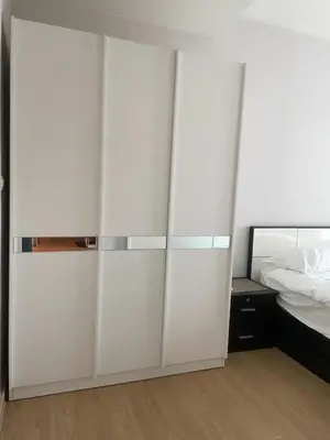 a bedroom with a large white cabinet next to a bed at Luxury Condominium in Bangkok