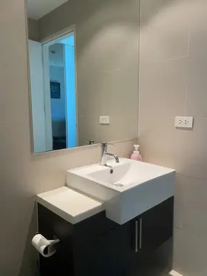 a bathroom with a white sink and a mirror at Luxury Condominium in Bangkok