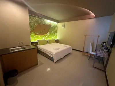 a bedroom with a bed and a sink and a television at Le Ram Hotel No window in Bangkok