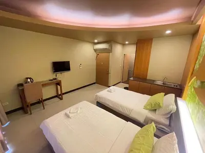 a hotel room with two beds and a tv at Le Ram Hotel No window in Bangkok