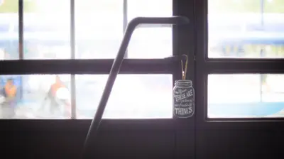 a door with a door knob with a sign on it at The rabbit's hole hostel in Bangkok