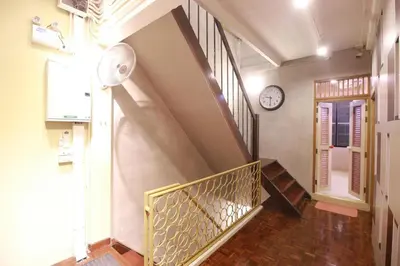 a staircase in a house with a clock on the wall at 168 Hostel in Bangkok
