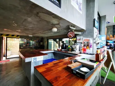a bar with a wooden counter in a restaurant at The Chilli Bangkok Hotel in Bangkok