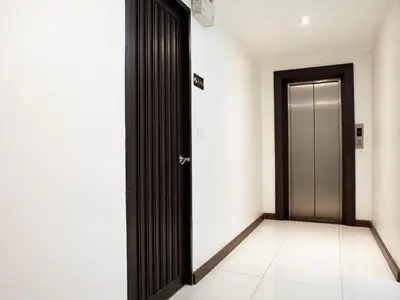 an empty hallway with a door and a tile floor at White House Asoke Sukhumvit 18 in Bangkok
