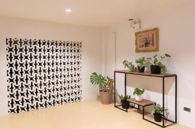 a room with potted plants and a wall at KOWTHA RIVERTEL in Bangkok