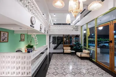 a lobby with green and white walls and chairs and clocks at KOWTHA RIVERTEL in Bangkok