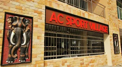 a store with a sign on the side of a building at AC Sport Village in Bangkok