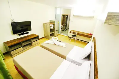 a room with two beds and a flat screen tv at AC Sport Village in Bangkok
