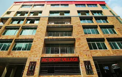 a tall brick building with a sign on it at AC Sport Village in Bangkok