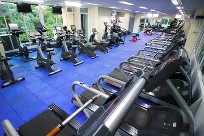 a gym with rows of treadmills and machines at AC Sport Village in Bangkok