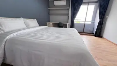 a large white bed in a room with a window at We Resident in Ban Bang Toei (1)